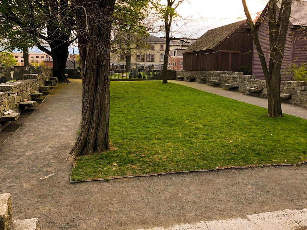 Stone benches and lawn at the Salem Witch Trials Memorial